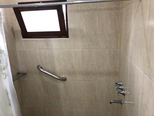 La salle de bains est pourvue d'une douche et d'une fenêtre. dans l'établissement Hermosa y confortable cabaña, à Puerto Iguazú