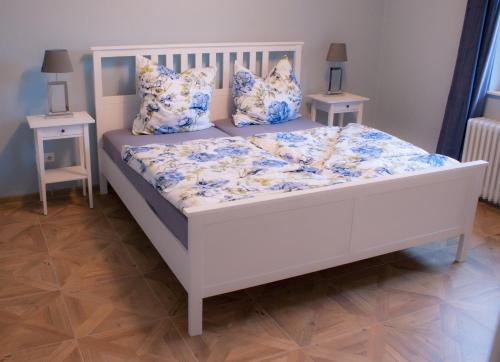 Cama blanca con sábanas y almohadas azules y blancas en Ferienwohnung Katzenstein im Harz, en Bad Sachsa