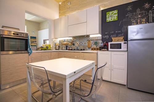 a kitchen with a white table and a refrigerator at 28 Peter in Sliema