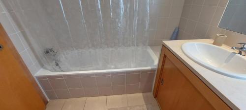 een badkamer met een douche, een wastafel en een bad bij Zise Flor-de-Lis in Conceição