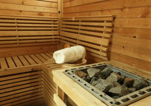 a sauna with a tub of rocks and a towel at Parador de Cardona in Cardona