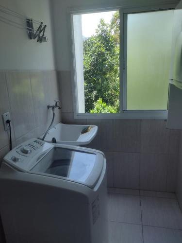 a bathroom with a sink and a window at Apartamento Centro de Ubatuba in Ubatuba