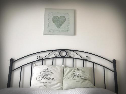 a bed with two pillows and a picture of a heart at The Seaterra Reserve Penthouse with mountains&seaviews and rooftop terrace in Akanthou