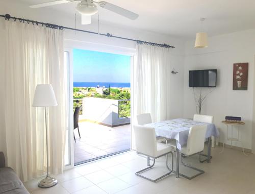 a dining room with a table and a view of the ocean at The Seaterra Reserve Penthouse with mountains&seaviews and rooftop terrace in Akanthou