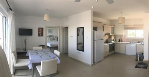 a kitchen with a table and chairs and a kitchen with a kitchen at The Seaterra Reserve Penthouse with mountains&seaviews and rooftop terrace in Akanthou