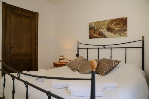 a bed with white sheets and pillows in a room at Il Cuore del Lago in Lazise