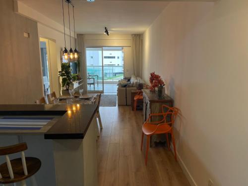 a kitchen and living room with a table and chairs at Apartamento ponta das galhetas ( praia Asturias ) in Guarujá