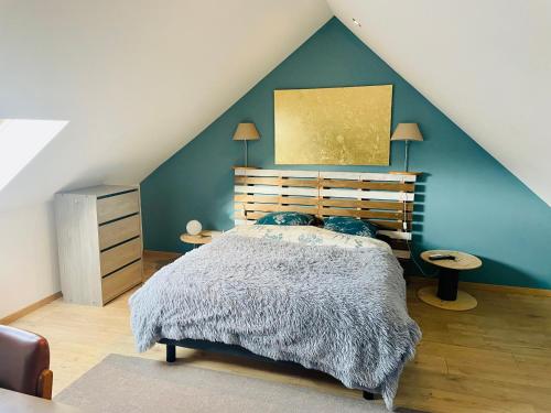 a bedroom with a bed and a blue wall at Iflex - 2P à 4P en Duplex - Henriville in Amiens