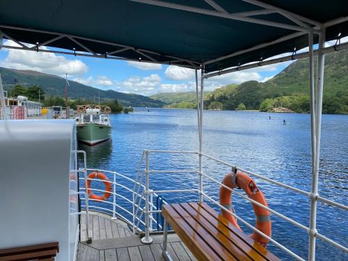 a bench on the deck of a boat on a lake at North View B&B in Penrith