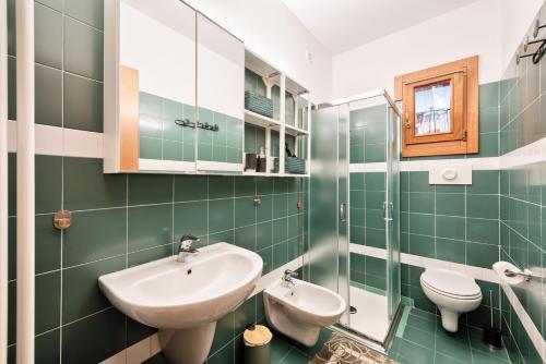 uma casa de banho verde com um lavatório e um WC em Piccolo Borgo di Raoul em Vicenza
