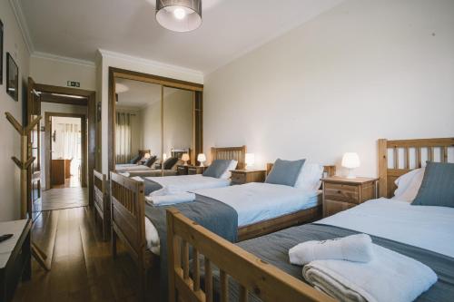 Zimmer mit 4 Betten und einem Spiegel in der Unterkunft Best Houses 33 - Conchas do Mar in Peniche