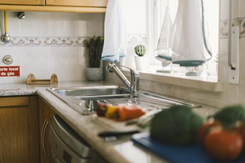 una encimera de cocina con fregadero y verduras en una tabla de cortar en Best Houses 33 - Conchas do Mar, en Peniche