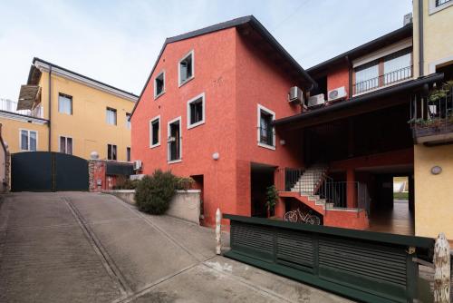 un bâtiment en briques rouges avec un portail vert devant lui dans l'établissement Piccolo Borgo di Raoul, à Vicence