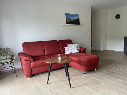 a living room with a red couch and a table at Weingut & Straußwirtschaft Vogel in Vogtsburg