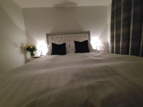 a bedroom with a large bed with two black pillows at Silver Sovereign in Banbridge