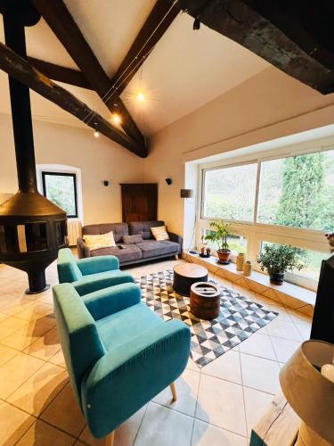 un salon avec un canapé et une cheminée dans l'établissement Batîsse le Moulinage du Luol avec parc arboré, à Saint-Privat