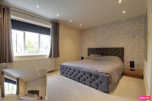 a bedroom with a large bed and a window at Luxurious 4 Bedroom Detached Family Home in Burton Joyce