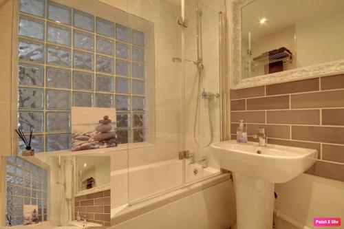 y baño con lavabo, aseo y ducha. en Luxurious 4 Bedroom Detached Family Home, en Burton Joyce