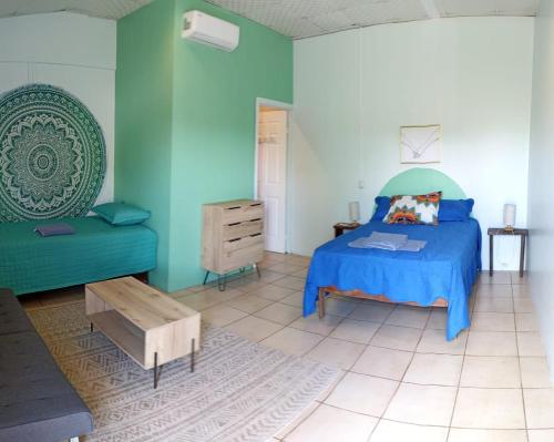 um quarto com uma cama azul e um sofá em The Sweet Escape Cabinas em Sierpe