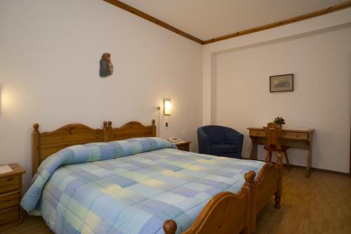 ボルカ・ディ・カドーレにあるHotel Villa Inesのベッドルーム1室(ベッド1台、デスク、椅子付)