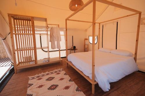 a bedroom with a canopy bed and a rug at 26North Glamping in Al Ula