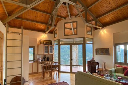 a living room and kitchen with a wooden ceiling at Villa Nano Καλάβρυτα βίλα στο βουνό με τζάκι in Kalavrita