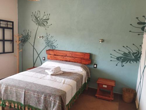 Un dormitorio con una cama con cabecero de madera. en Calli Sofi Posada, en Tepoztlán
