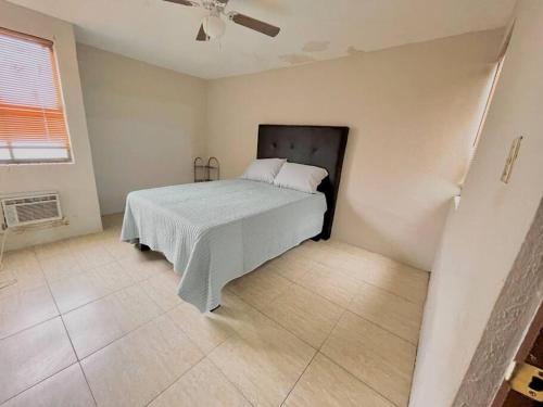 een slaapkamer met een bed en een plafondventilator bij Acogedor departamento 3 recamaras in Reynosa