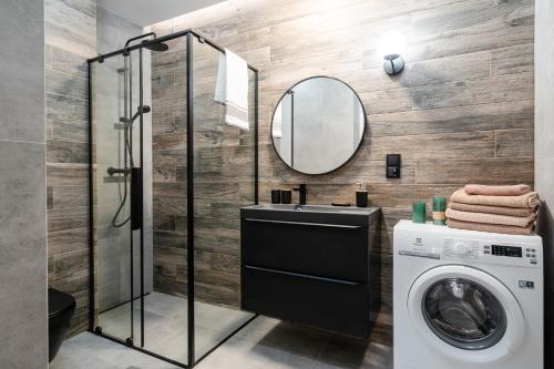 a bathroom with a washing machine and a mirror at LeoApart in Wrocław