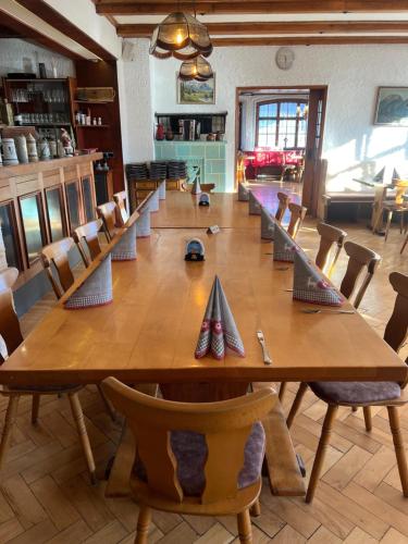 a large wooden table and chairs in a room at Gasthof Löwen in Pfronten