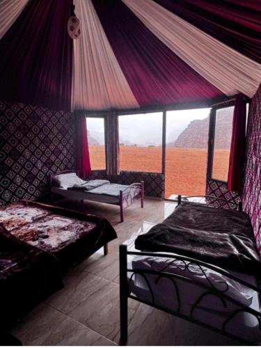 - une chambre avec 2 lits et une grande fenêtre dans l'établissement MOHAMMED ZAWAIDAH CAMP, à Wadi Rum