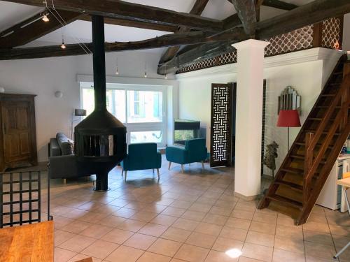 a living room with a fireplace and a staircase at Batîsse le Moulinage du Luol avec parc arboré in Saint-Privat