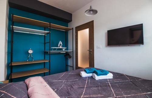 Krkulj Apartments في أوخريد: غرفة نوم بسرير وتلفزيون بشاشة مسطحة