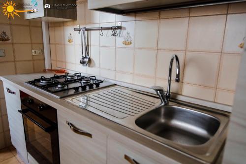 uma cozinha com um lavatório de aço inoxidável e um fogão em Cannotta Beach - Lipari em Terme Vigliatore