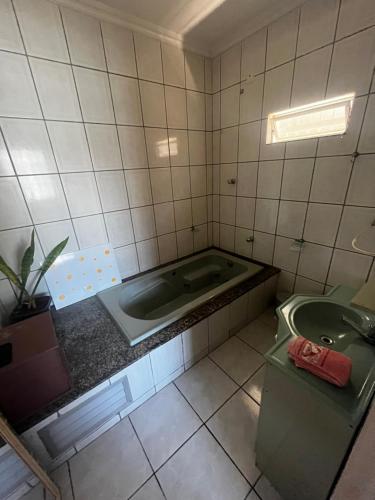 a bathroom with a tub and a sink at Casa de praia da Kenna, centro in Navegantes