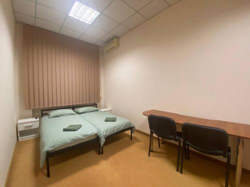 a bedroom with a bed and a table and chairs at Si-Yo hostel in Uzhhorod