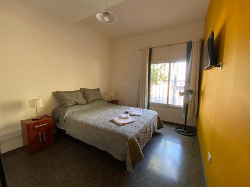 1 dormitorio con cama y ventana en departamento godoy cruz en Godoy Cruz