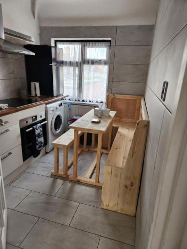 a small kitchen with a table and a washing machine at 12 Minutes to Central London Kings Cross, 6 minutes walks to the train station - Free parking 3 bed 2 bath fully refurbished flat NO PARTY OR GATHERING ALLOWED in London