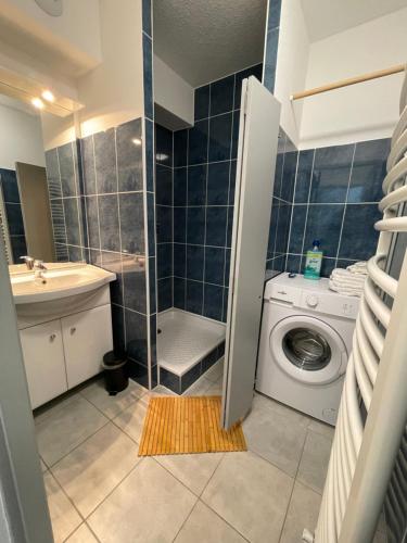 a bathroom with a washing machine and a shower at Easy Location - Parking - Free Wifi - Tourism and Business in Freyming