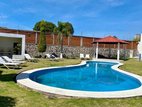 una piscina nel cortile di una casa di Hermoso departamento en Cuautlancingo a Santa María Coronanco