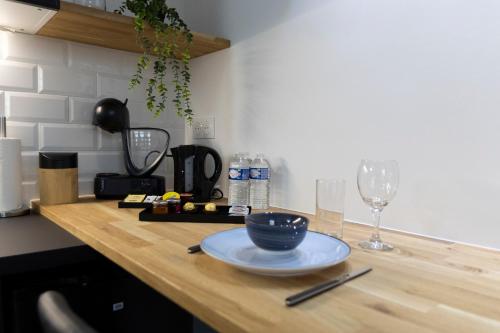 a wooden counter with a plate and wine glasses on it at Easy Location - Parking - Free Wifi - Tourism and Business in Freyming