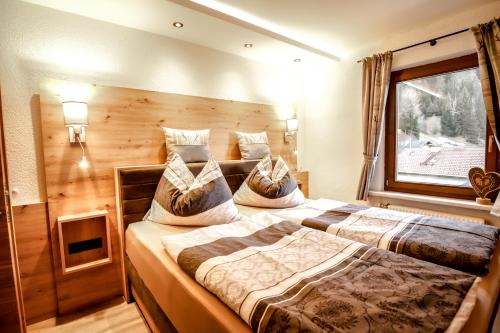 two beds in a room with a window at Gasthof Geraerhof in Vals