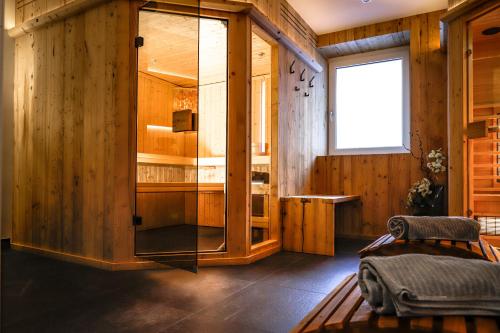 een kamer met houten wanden, een raam en een glazen kast bij Gasthof Geraerhof in Vals