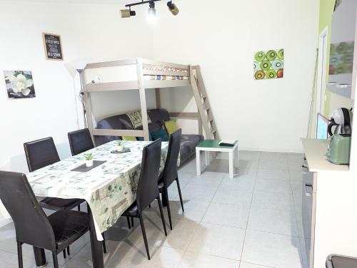 a dining room with a table and chairs and a bunk bed at Appartement entier meublé à Beaumont proche Futuroscope et Poitiers Technopole in Beaumont