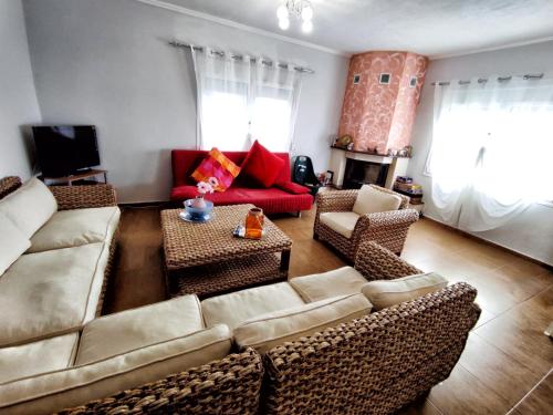 a living room with a couch and chairs and a table at ALEX HOUSE in Nea Potidaea