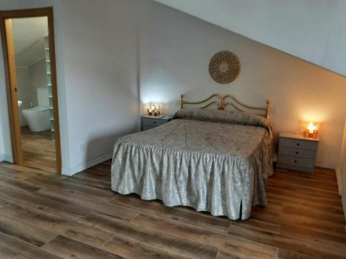 a bedroom with a bed and a bathroom with a mirror at Casa Rural Horizontes de la Mancha in El Toboso