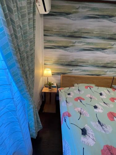 a bedroom with a bed with a painting on the wall at 舟荘 in Osaka