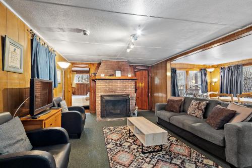 a living room with a couch and a fireplace at Sun Valley Cottages in Weirs Beach