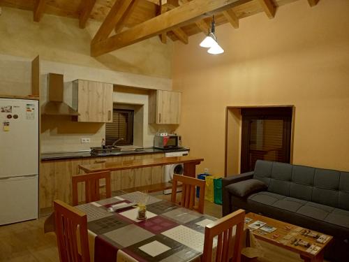 a kitchen and living room with a table and a couch at Casa la ti María la viuda in Riego de Lomba