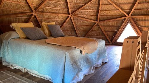 Cama en habitación con techo en Domo Amanita, confortable y playero!, en Punta del Diablo